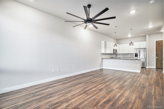 unfurnished living room featuring ceiling fan, sink, and dark wood-type flooring