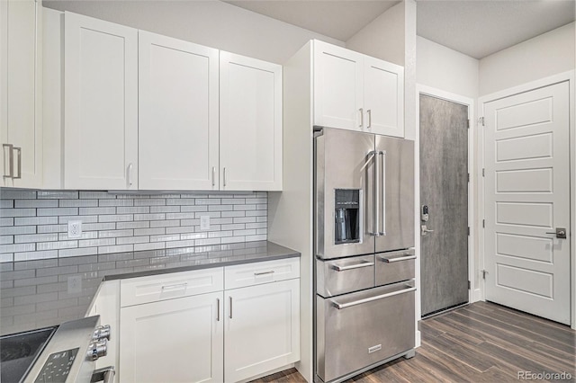 kitchen with decorative backsplash, white cabinetry, dark hardwood / wood-style flooring, and appliances with stainless steel finishes