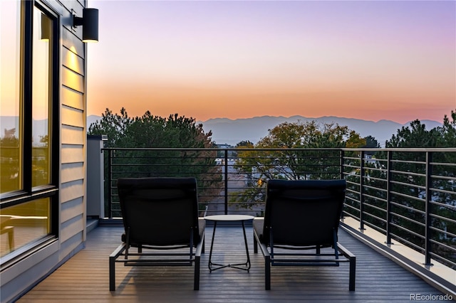 balcony at dusk featuring a mountain view