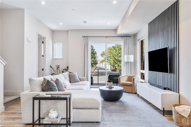 living area featuring baseboards, visible vents, wood finished floors, and recessed lighting