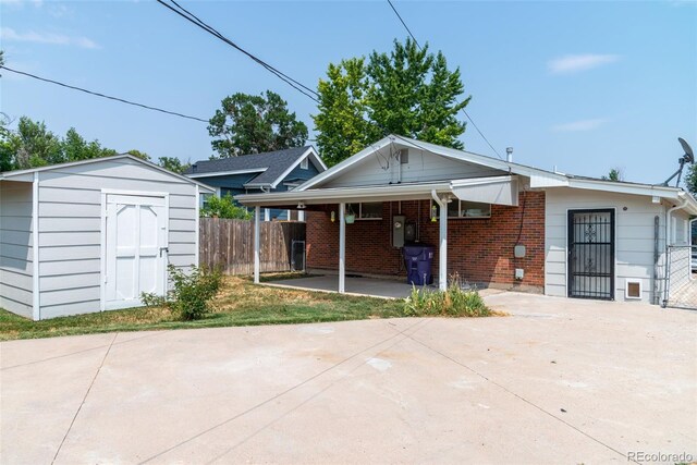 view of front of property with a storage shed and a carport