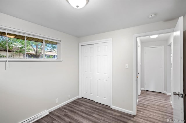 4785 Carr St, Wheat Ridge, CO 80033 - unfurnished bedroom featuring dark wood-style flooring, a closet, and a baseboard radiator