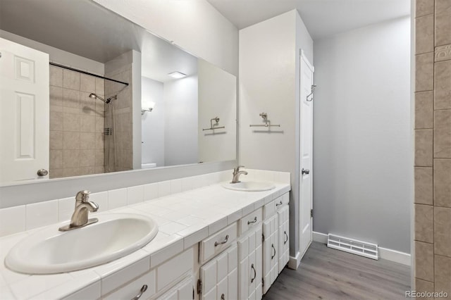 bathroom with toilet, vanity, and hardwood / wood-style floors