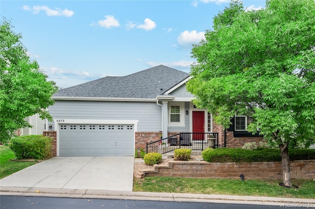 view of front of property with concrete driveway, brick siding, roof with shingles, and an attached garage