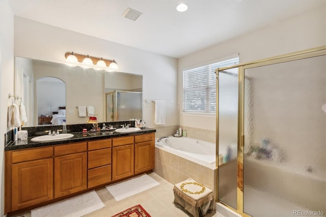 ensuite bathroom with a garden tub, a sink, a shower stall, and ensuite bathroom