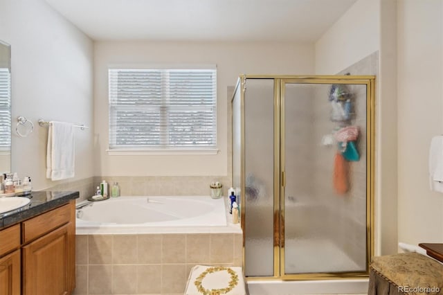 full bathroom with a garden tub, vanity, and a shower stall