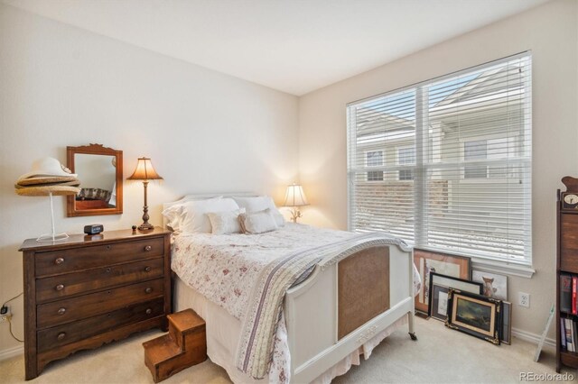 bedroom with light carpet and baseboards