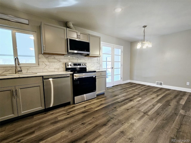 kitchen featuring sink, decorative light fixtures, dark hardwood / wood-style flooring, gray cabinets, and stainless steel appliances