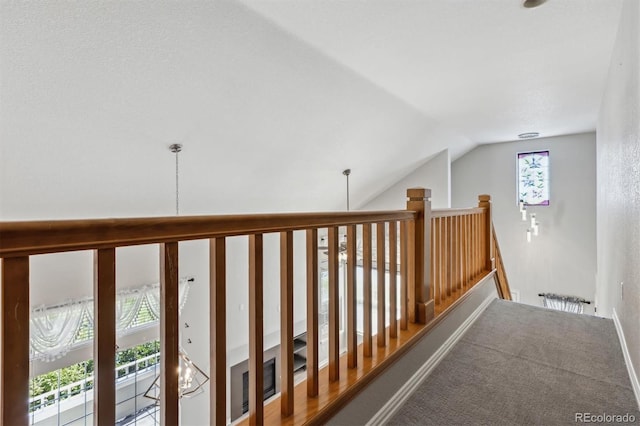 corridor featuring lofted ceiling and carpet flooring