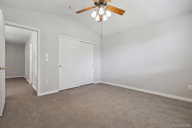 unfurnished bedroom with a closet, dark colored carpet, vaulted ceiling, and ceiling fan