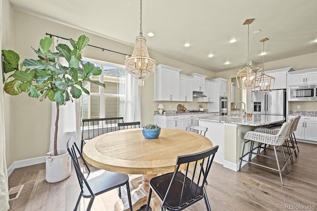 15033 Delhi Ave, Parker, CO 80134 - dining room with a chandelier, wood finished floors, recessed lighting, and baseboards