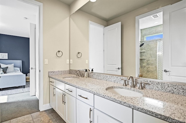 15033 Delhi Ave, Parker, CO 80134 - ensuite bathroom with double vanity, a tile shower, tile patterned flooring, and baseboards