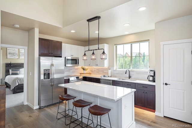 327 Summit Lift Ct, Granby, CO 80446 - kitchen with appliances with stainless steel finishes, a sink, a kitchen bar, recessed lighting, and light wood finished floors