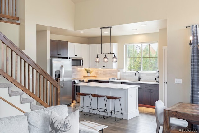 327 Summit Lift Ct, Granby, CO 80446 - kitchen featuring stainless steel appliances, light wood finished floors, light countertops, tasteful backsplash, and a kitchen island