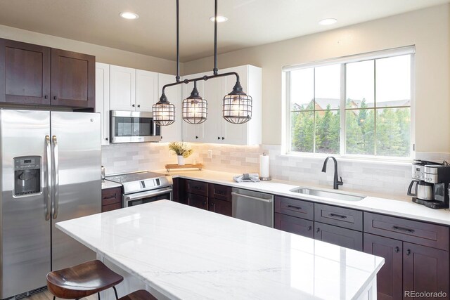 327 Summit Lift Ct, Granby, CO 80446 - kitchen with stainless steel appliances, a sink, a kitchen bar, tasteful backsplash, and recessed lighting