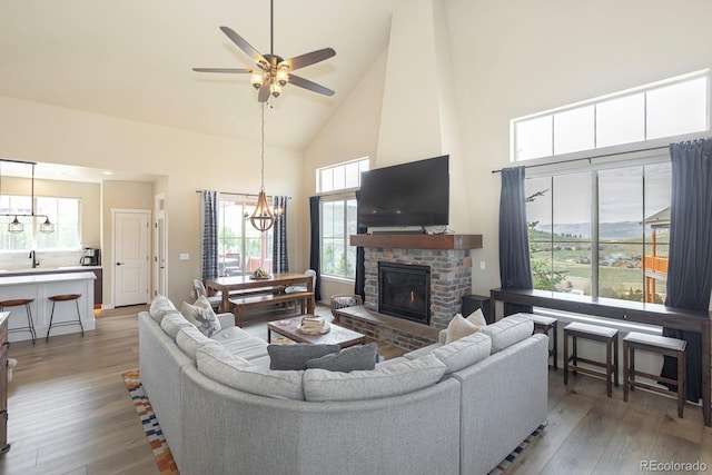 327 Summit Lift Ct, Granby, CO 80446 - living area featuring high vaulted ceiling, a chandelier, wood finished floors, a ceiling fan, and a glass covered fireplace
