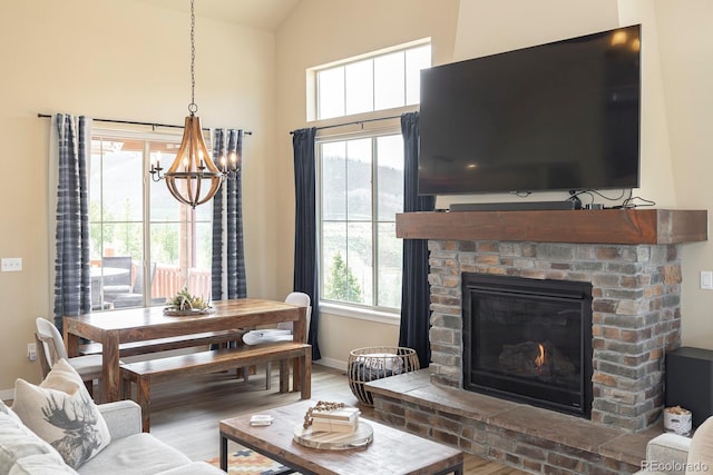 327 Summit Lift Ct, Granby, CO 80446 - living room with a chandelier, wood finished floors, a brick fireplace, baseboards, and high vaulted ceiling