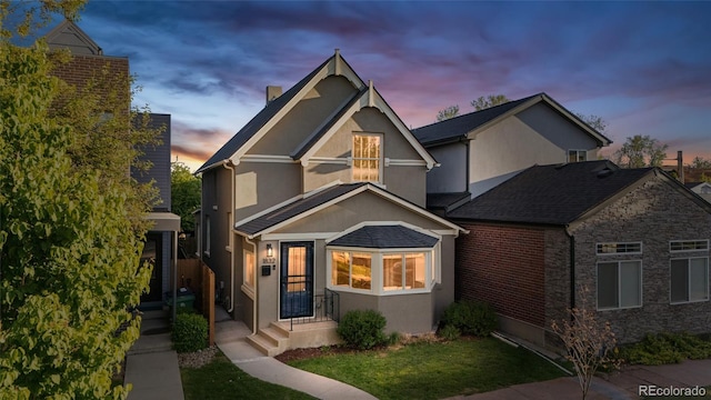view of front of property featuring stucco siding and a lawn