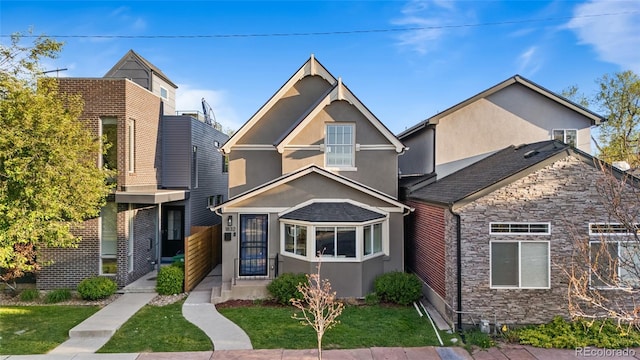view of front of house featuring stone siding, stucco siding, and a front yard