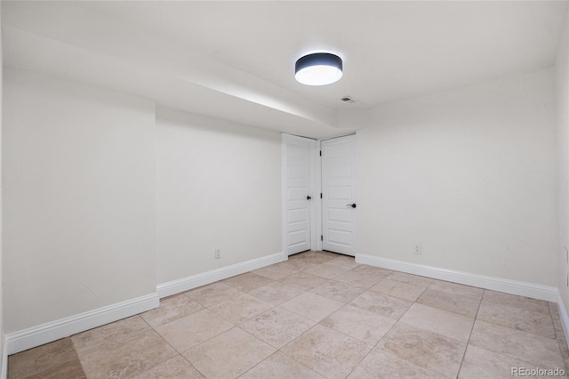 unfurnished room featuring baseboards and light tile patterned flooring