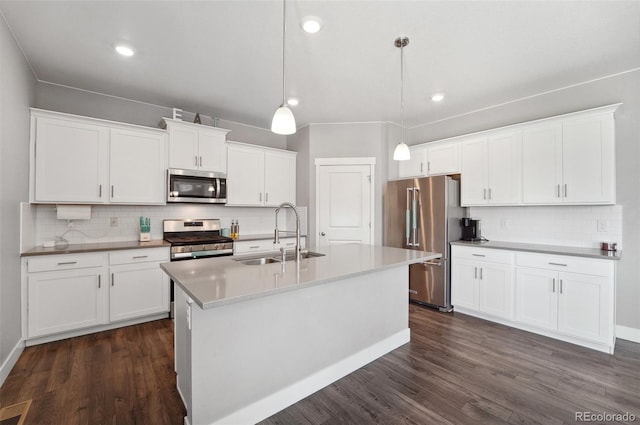 2128 Dexter St, Mead, CO 80542 - kitchen with stainless steel appliances, decorative backsplash, dark wood-type flooring, an island with sink, and white cabinets