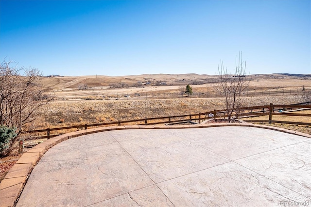 view of patio / terrace with fence and a mountain view