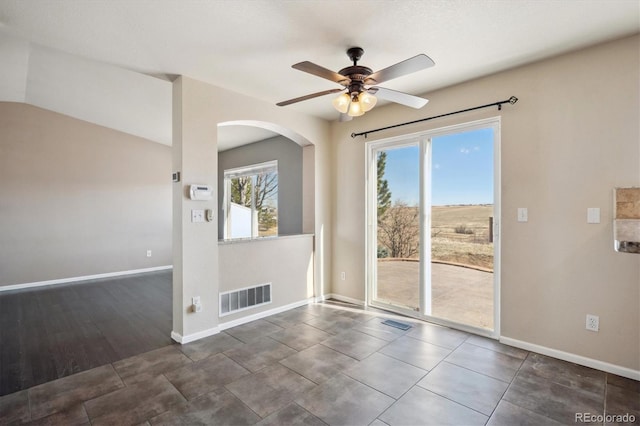 unfurnished room with ceiling fan, tile patterned flooring, visible vents, and baseboards