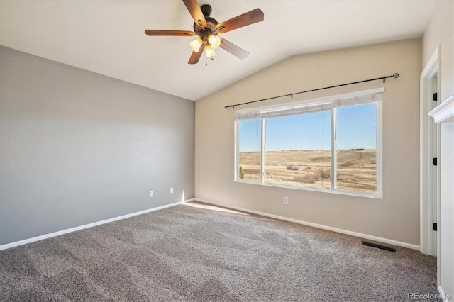 carpeted empty room with vaulted ceiling, a ceiling fan, visible vents, and baseboards