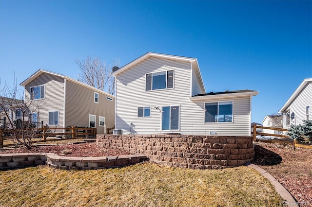 rear view of house featuring a yard and fence