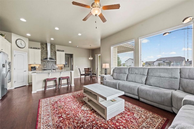 living room with dark hardwood / wood-style flooring and ceiling fan