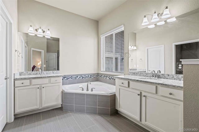 bathroom with vanity, tile patterned floors, and tiled bath