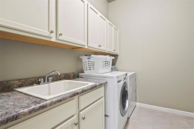 washroom featuring cabinets, sink, light tile patterned flooring, and washing machine and dryer