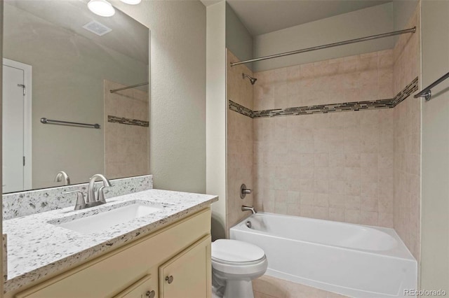 full bathroom with tile patterned flooring, tiled shower / bath, toilet, and vanity