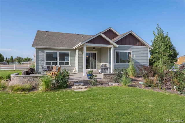 view of front of property with ceiling fan, a patio area, and a front yard