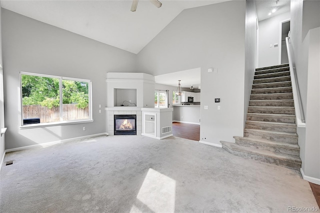 19873 E Vassar Ave, Aurora, CO 80013 - unfurnished living room featuring high vaulted ceiling, carpet flooring, baseboards, stairway, and ceiling fan