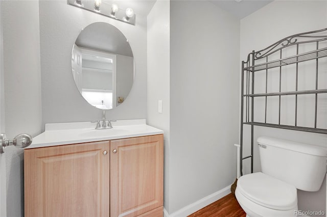 19873 E Vassar Ave, Aurora, CO 80013 - half bath with toilet, vanity, baseboards, and wood finished floors