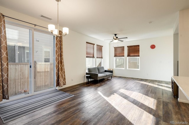 unfurnished room featuring baseboards, visible vents, dark wood finished floors, and ceiling fan with notable chandelier