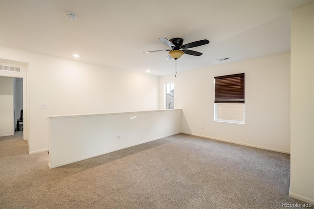 spare room with recessed lighting, visible vents, light carpet, and baseboards