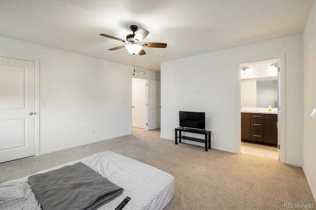 bedroom featuring baseboards, ceiling fan, ensuite bathroom, and light colored carpet