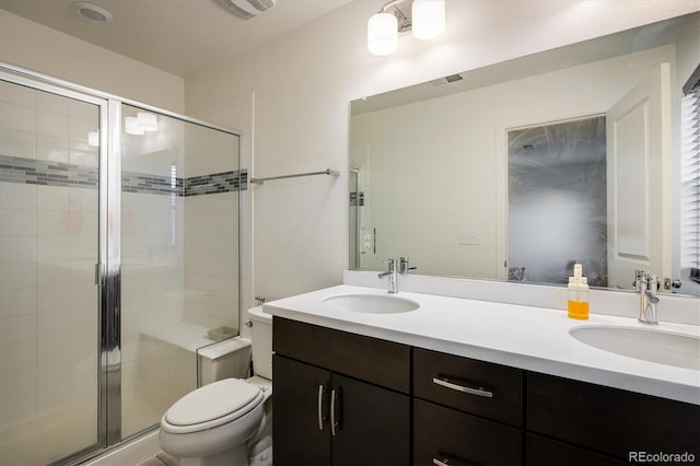 bathroom featuring toilet, double vanity, a sink, and visible vents