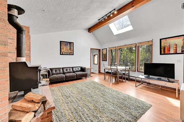 101 Campbell Rd, Bailey, CO 80421 - living room with wood finished floors, a skylight, rail lighting, beamed ceiling, and a textured ceiling