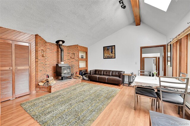 101 Campbell Rd, Bailey, CO 80421 - living room with light wood finished floors, a wood stove, and a skylight