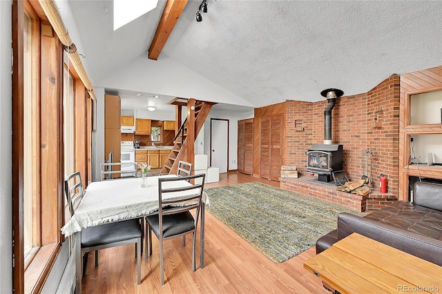 101 Campbell Rd, Bailey, CO 80421 - dining space with light wood finished floors, a wood stove, and stairway