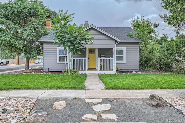 view of front of house with covered porch and a front yard