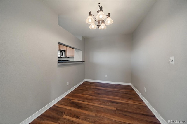 unfurnished dining area with dark hardwood / wood-style floors and a notable chandelier