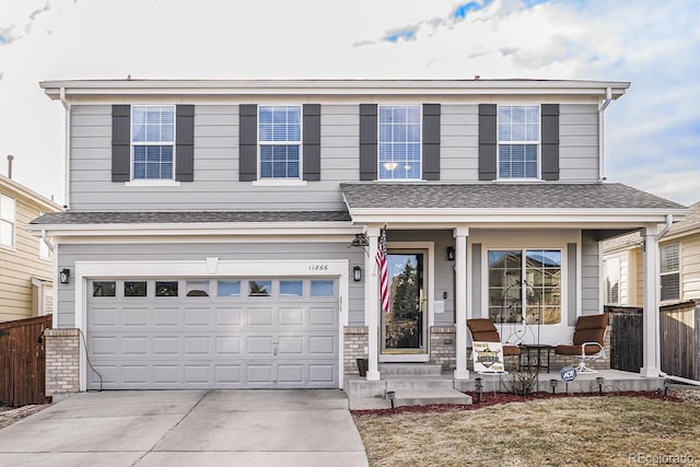 view of front of house featuring covered porch, driveway, a garage, and fence