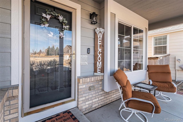 entrance to property with brick siding and covered porch