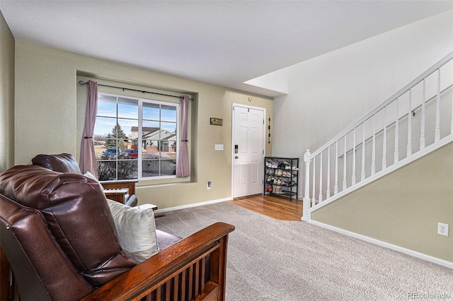 carpeted entrance foyer with stairway and baseboards