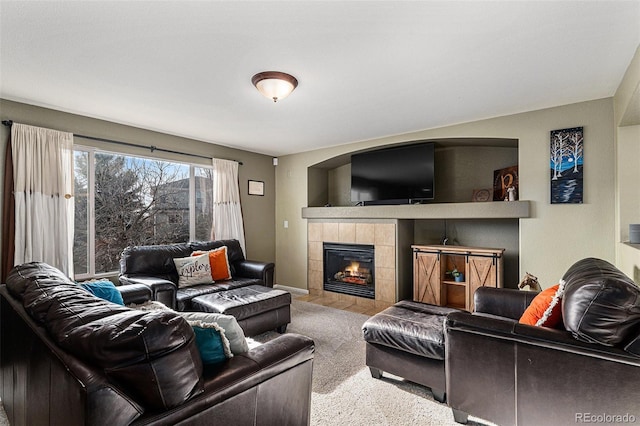 living area featuring baseboards, carpet floors, and a tile fireplace