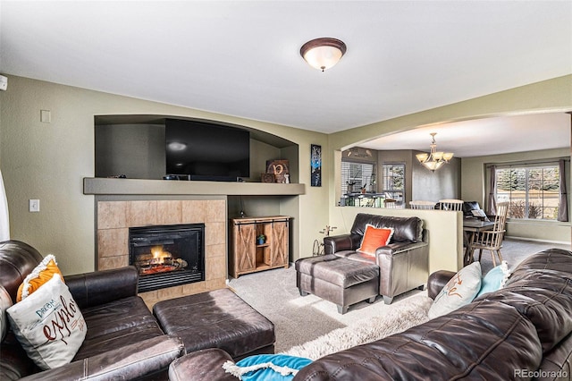 carpeted living area featuring a chandelier and a fireplace